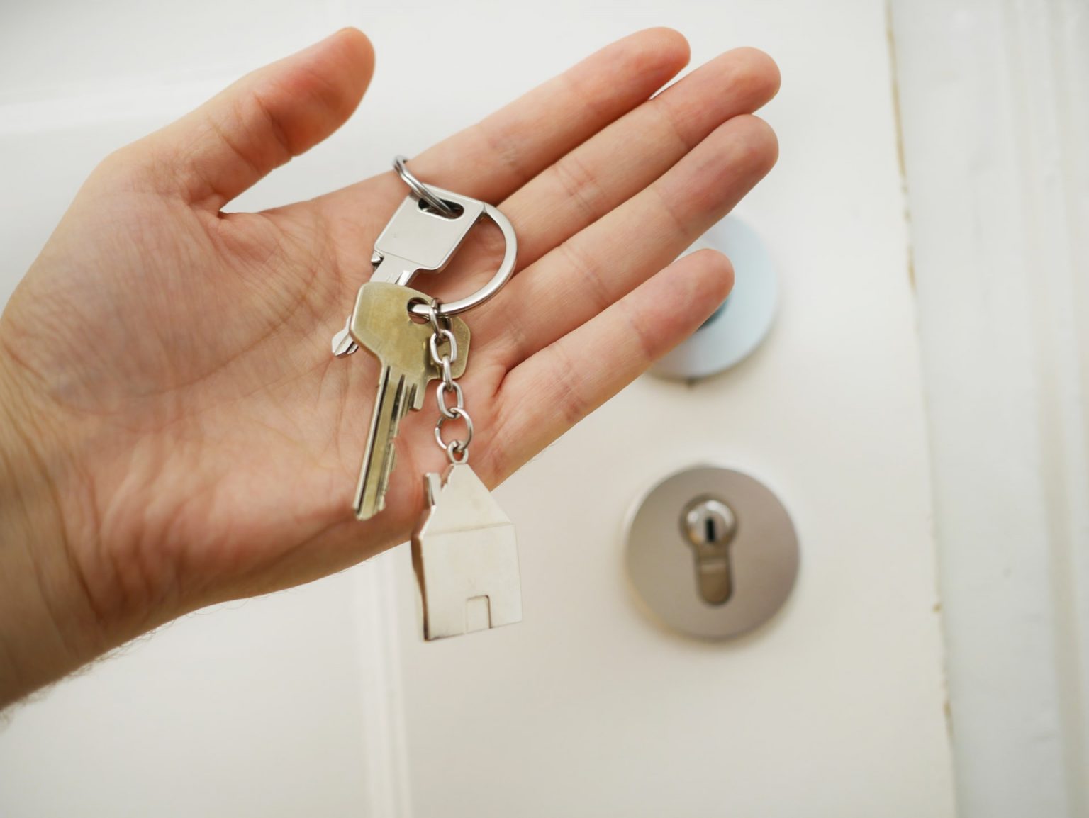 House keys held beside a door